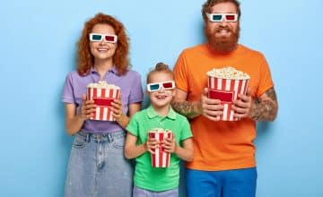 family members enjoy watching television with popcorn