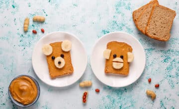 funny bear monkey face sandwich with peanut butter banana black currant top view